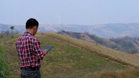 Engineers use the tablet to inspect wind turbines Stock Footage 124962825
