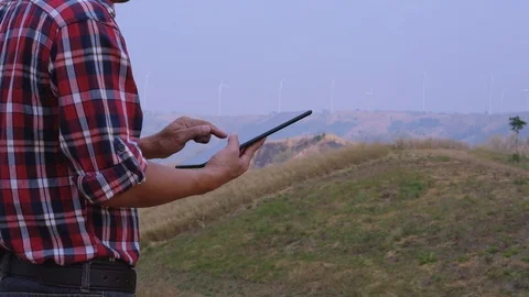 Engineers use the tablet to inspect wind turbines Stock Footage 124962876