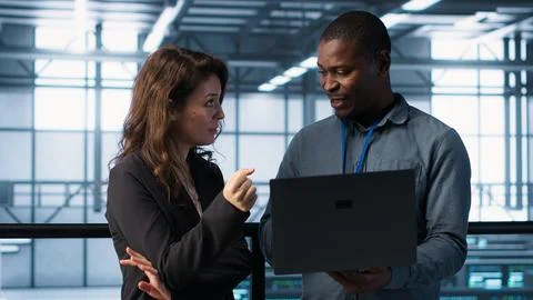 Engineers using laptop in data center, managing server virtualization 스톡 사진