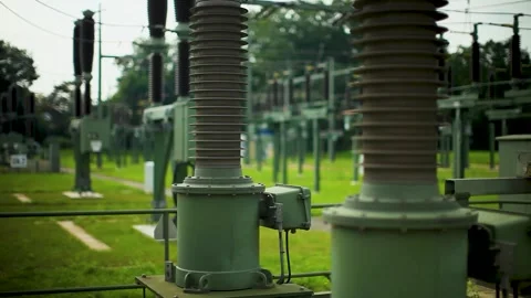 Engineers Walk Through Electrical Substation Yard with Industrial Equipment Outd Stock Footage 334054112