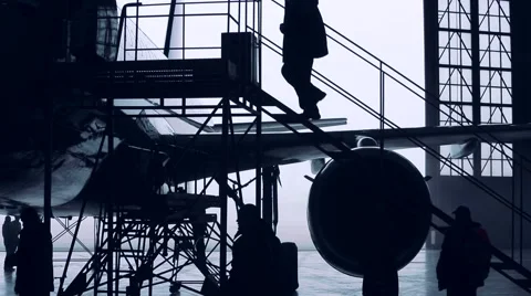 Engineers work with the aircraft in the hangar. Silhouette time lapse Stock-Footage 45296422