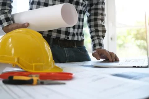 Engineers work with laptops and blueprints. Calculate and check the construct Foto stock