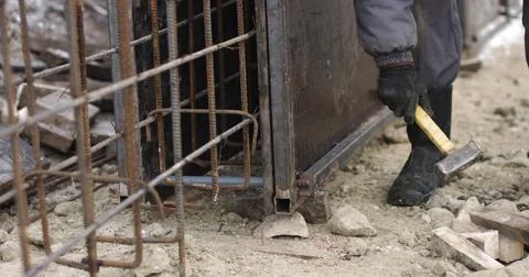 Engineers work with metal constructions while building a house. The worker fixes Fotos de archivo