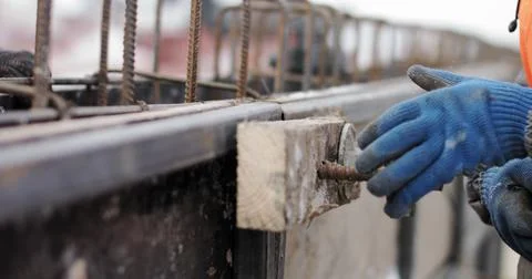 Engineers work with metal constructions while building a house. The worker fixes Fotos de archivo