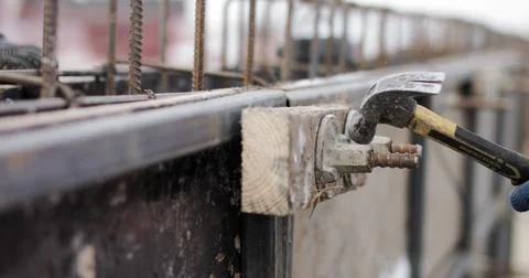 Engineers work with metal constructions while building a house. The worker fixes Fotos de archivo