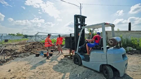 Engineers work together. Builders in bright uniform build new solar farm  Stock Footage 134794321