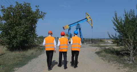 Engineers Worker Men Talking Petroleum Installations Walking in Oil Pump Field Stock Photos