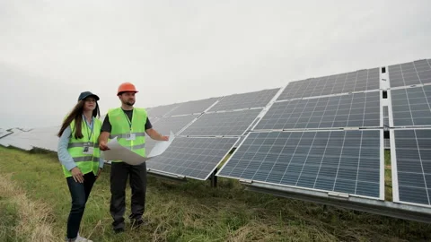 Engineers workers holding solar plan in hands and standing near solar panel Stock Footage 156811998