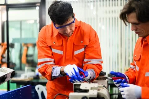 Engineers working and solving problems on machine at industrial plant Foto stock