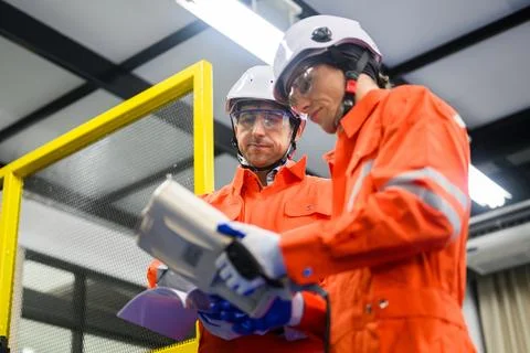 Engineers working and solving problems on machine at industrial plant Foto stock