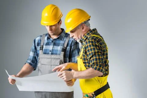 Engineers working with blueprint Stock Photos