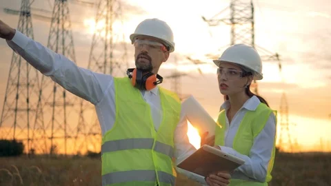Engineers working with construction project near high voltage line, voltage line Stock Footage 93997276