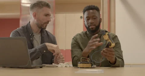 Engineers working with robot arm in technology company office Video stock 165064992