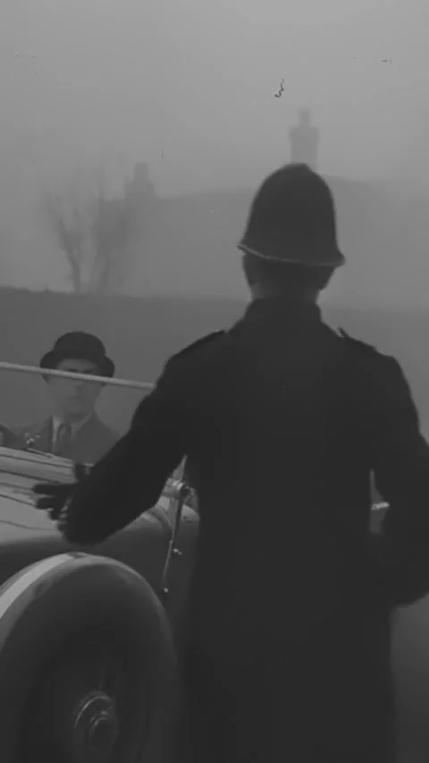 ENGLAND - 1930s - A driver is stopped by a policeman in a foggy English village, Stock Footage 342258527