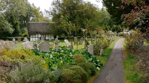 ENGLAND  CIRCA 2011: Pan from grave stones to old english church to grave sto Stock Footage 99624950