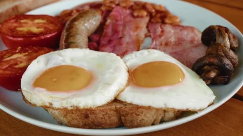 English breakfast close up - fried eggs, sausages, bacon, tomatoes, tomato beans Stock Footage 201395416
