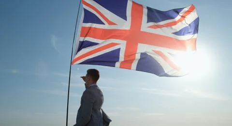 An Englishman stands under the developing flag of Great Britain Stock Photos