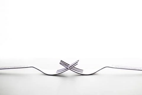 Engraved silverware fork set of two placed face to face crossing their teet.. Stock Photos