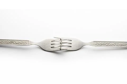 Engraved silverware fork set of two placed face to face crossing their teet.. Stock Photos