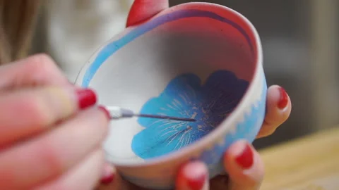 Engraving with a metal stack on the bottom of a ceramic clay bowl for pottery Stock Footage 256323896