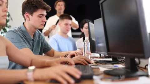 Engrossed in his work, student sits near computer, fully immersed in his studies Stock Footage 327698951