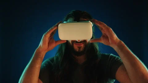 Engrossed Man Putting on VR Headset to Interact with Virtual Environments Stock Footage 269210330