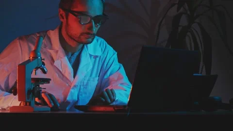 Enhanced color scheme in the blue range.A young researcher in a white coat and g Stock Footage 171724341