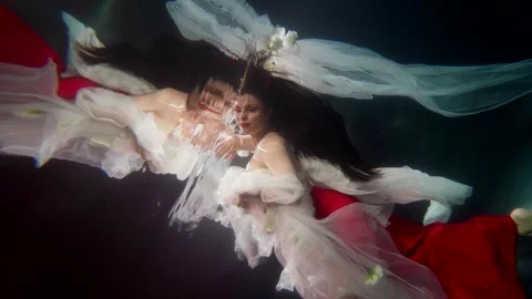 Enigmatic lady and her reflection underwater, pretty brunette swimming in 動画素材 243674916