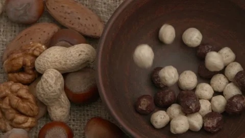 Enjoy Assorted Nuts and Treats beautifully presented in a Rustic Setting that 動画素材 289997053