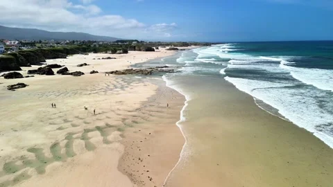 Enjoy the breathtaking aerial view of a sandy beach and gentle ocean waves at Stock Footage 309621888