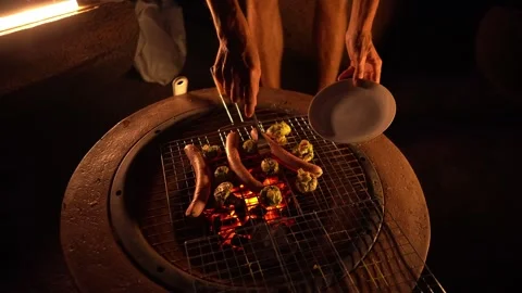 Enjoy the cozy atmosphere while grilling sausages and vegetables over an open Stock-Footage 283201247