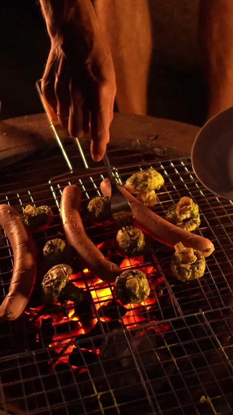 Enjoy the cozy atmosphere while grilling sausages and vegetables over an open Stock Footage 284708815