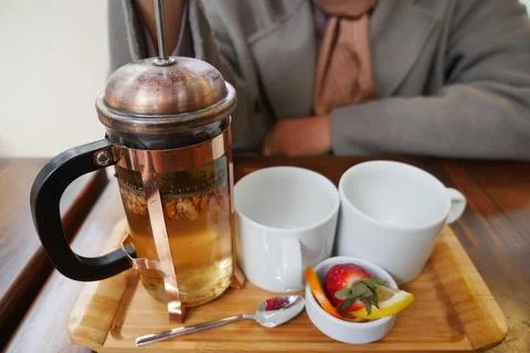 Enjoy a cozy tea experience featuring a delightful French press and an array of Foto stock