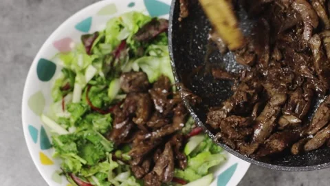 Enjoy a delicious serving of stirfried beef accompanied by a refreshing, fresh Stock Footage 301633056