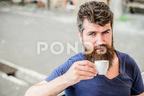 Enjoy hot drink. Hipster drinking fresh brewed coffee. Bearded guy consume Stock Photos