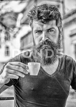 Enjoy hot drink. Hipster drinking fresh brewed coffee. Bearded guy consume Stock Photos