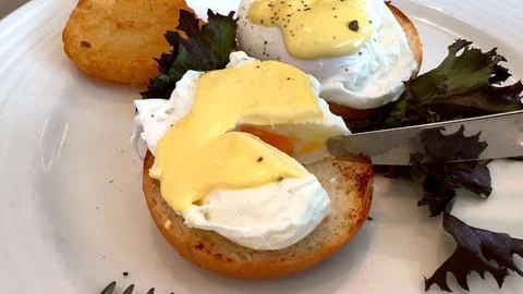 Enjoy nutritious breakfast with eggs Benedict and fresh greens, crafted using Stock Photos