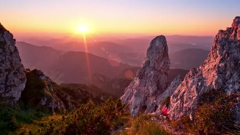 Enjoy the stunning view of the sun setting over the mountain peaks in a Stock Footage 294595731
