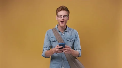 Enjoyed happy Red-haired handsome man point finger at phone recommended app Video stock 200873273