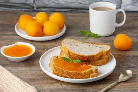 Enjoying breakfast with bread, apricot jam, and coffee in a cozy kitchen Foto stock