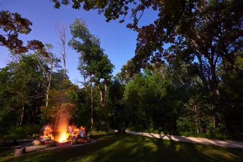 Enjoying a campfire on a summer night. Stock Photos