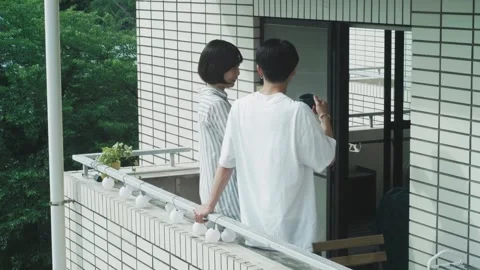 Enjoying Conversation Over Coffee on the Balcony Stock Footage 332859872