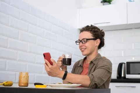 Enjoying a delicious breakfast while scrolling casually through my phone for Stock Photos