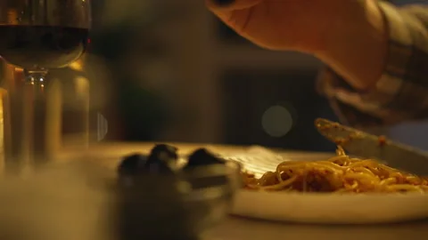 Enjoying a delicious plate of spaghetti during a candlelit dinner at home Stock Footage 323764127
