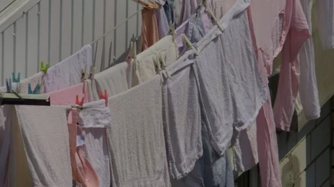 Enjoying the delightful experience of clothes drying outdoors under the warm sun Stock Footage 309801627