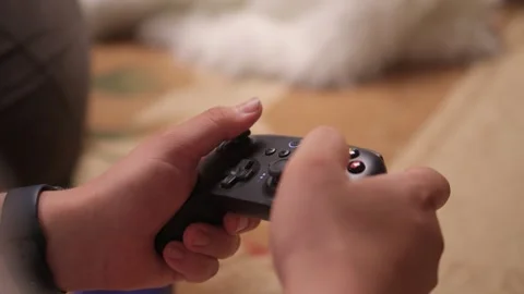 Enjoying an exciting gaming session with a controller and large screen for Video stock 315919158