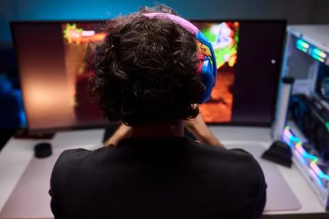 Enjoying an exciting gaming session with a controller and large screen for Foto stock