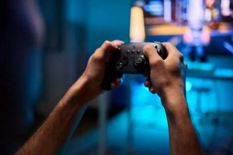 Enjoying an exciting gaming session with a controller and large screen for Foto stock