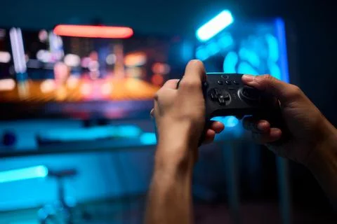 Enjoying an exciting gaming session with a controller and large screen for Foto stock