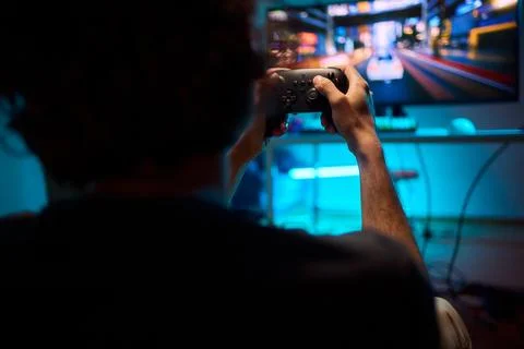 Enjoying an exciting gaming session with a controller and large screen for Foto stock